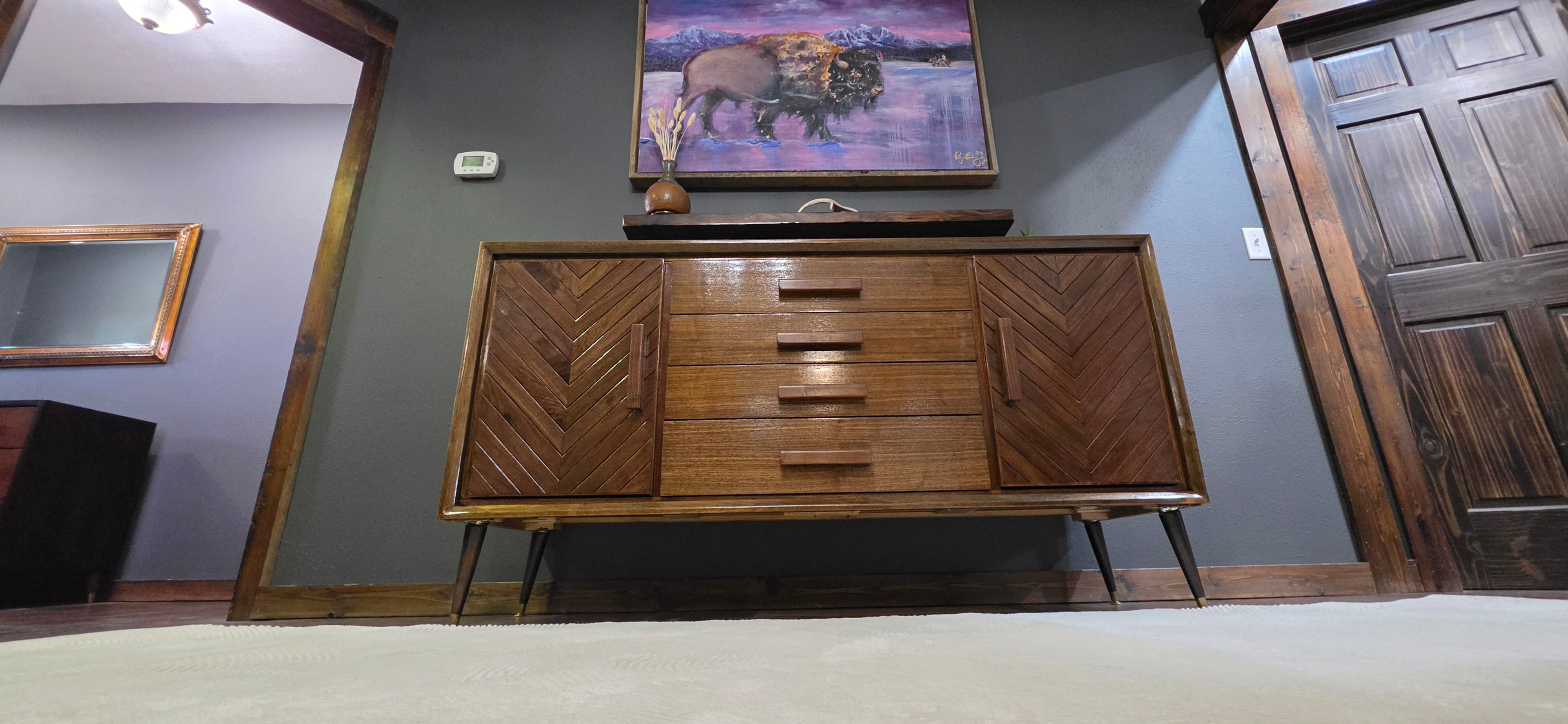 Custom refinished walnut credenza with floating walnut shelf and buffalo painting